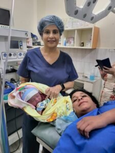 Dr. Malti Bhojwani holding newborn baby after successful delivery at Malti Hospital & Test Tube Baby Centre in Bhopal